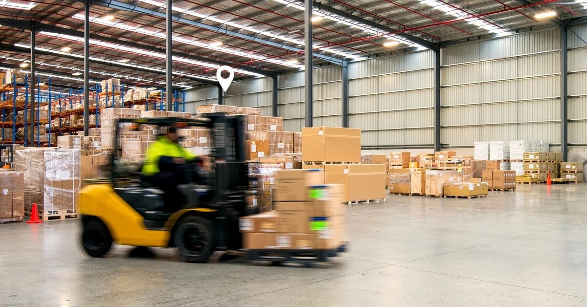 A forklift transporting assets across a warehouse.