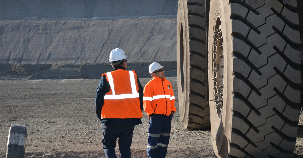 Industriearbeiter arbeiten in der Nähe eines großen Lkw.